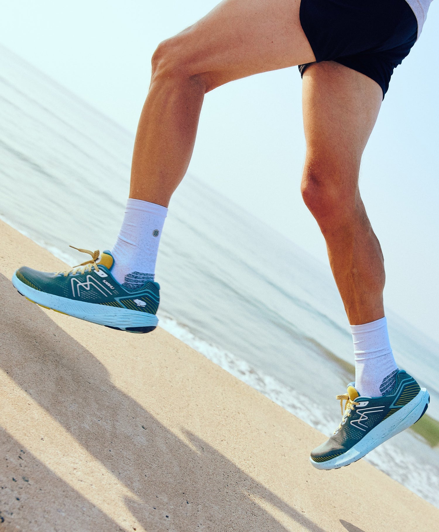 Men's KARHU Ikoni 2.5 wide fit running alongside the beach